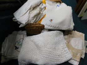 A wicker storage basket and contents of linen.