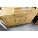 A beech sideboard, with arrangement of two cupboard doors and three drawers.