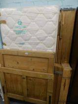 A pine single bed frame and mattress.