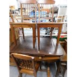 An oak extending dining table and three matching chairs.