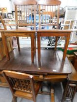 An oak extending dining table and three matching chairs.
