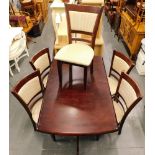 A mahogany extending kitchen table and five matching chairs.