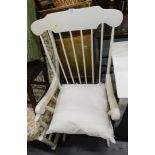A cream painted rocking chair.