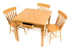 A miniature pine farmhouse table and three chairs.