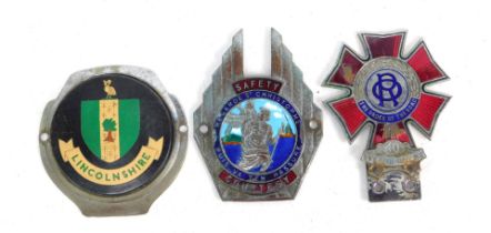 Three car badges, including a Order of the Road 40 Year Driver badge, a Saint Christopher badge, and