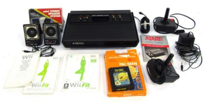 An Atari 2600, with two controllers, transformer, Pac-Man, and a copy of Wii Fit for the Nintendo Wi