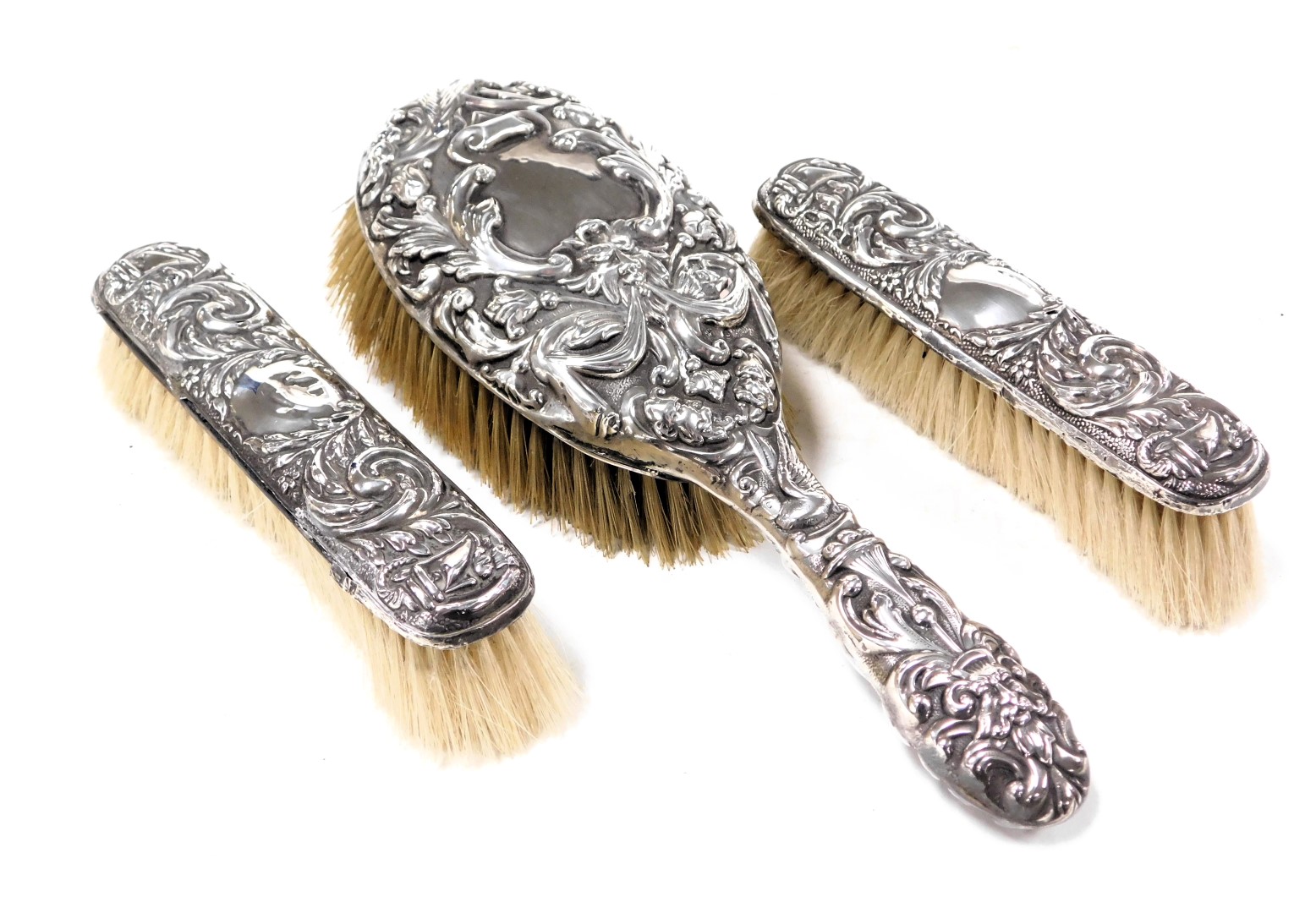 An Edward VII silver back hair brush, embossed with masks, birds, drapes and foliate scrolls, London