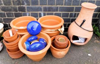 Various ceramic garden planters and a large fire with metal stand.