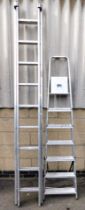 Two pairs of aluminum step ladders.