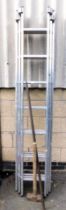 A set of three tier aluminum ladders, lump hammer and a long metal pry bar.