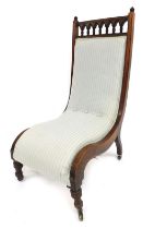 A late Victorian mahogany framed low seated nursing chair, with spindle gallery upper rail, on turne