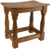 A Robert 'Mouseman' Thompson of Kilburn oak stool, with rectangular curved seat, raised on turned le