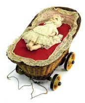 A 19thC German wax automation pram and doll, with bisque headed doll, possibly Moschmann.