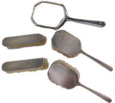 A matched silver dressing table set, comprising hand mirror, two hand held brushes, and two long bru