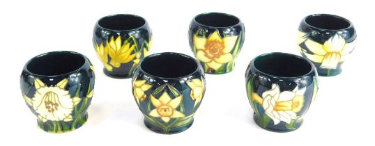 A set of six Moorcroft pottery miniature vases, each of differing design decorated with daffodils, i