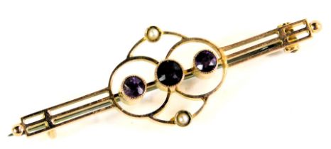 An Edwardian bar brooch, the central design set with three amethysts and two seed pearls on two bar