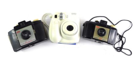 A Fujifilm Instax mini camera, a Kodak Cresta 2 camera, and a boxed Kodak Brownie 127. (3)