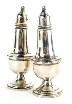 A pair of Empire salt and pepper pots, each of baluster form, with pierced top and acorn finial, on