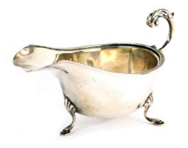 A Victorian silver sauce boat, with a reeded border and acanthus leaf scroll handle, on shell capped