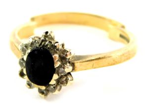 A 9ct gold cluster ring, the central oval sapphire in rub over setting, with diamond set borders, 2.