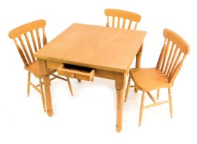 A pine farmhouse table and three chairs.