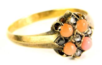 An Edwardian 15ct gold coral and diamond cluster ring, set with four corals and five tiny diamonds,