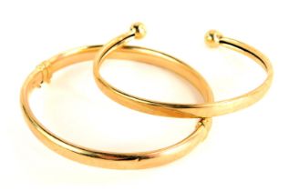 Two bangles, comprising a 9ct gold half hinged bangle, and a two row torque bangle, yellow metal unm