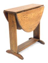 A 1930s oak oval drop leaf occasional table, with flat plain supports and stretcher, 51cm high.