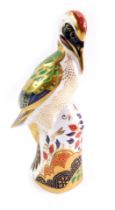 A Royal Crown Derby porcelain paperweight modelled as Green Woodpecker, gold stopper and red printed