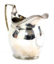 A George III silver cream jug, with bright cut beaded decoration and central crest formed as a wreat