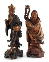 Two Oriental hardwood carvings, depicting an immortal holding staff with animal seated at feet, 24cm