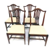 A set of four Hepplewhite mahogany dining chairs, with arched backs and pierced splats, drop in