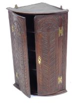 A 19thC carved oak cylinder front corner cabinet, with three shelves to the interior, 90cm high, 60c