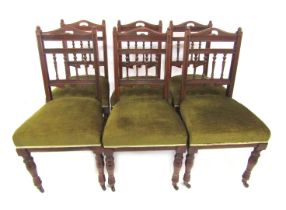 A set of six Edwardian mahogany dining chairs, each with a carved and turned column rail, overstuffe