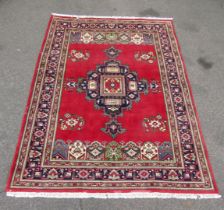 A Persian red ground carpet, with multiple central medallions within multiple floral and leaf decora