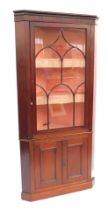 A late 19thC mahogany standing corner cabinet, the top with a fluted frieze, above an astragal glaze