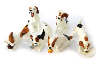 A group of Royal Doulton porcelain figures modelled as Jack Russells, in various poses, playing with