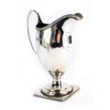A George V silver cream jug, with a triple moulded border, on plain design, on a square stepped foot