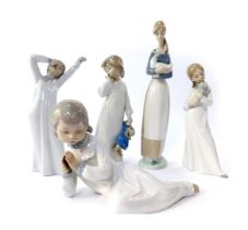A group of Nao porcelain figures, modelled as child yawning, 22cm high, child holding puppy, 20cm hi