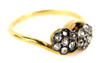 A diamond cluster ring, formed as two daisies set with tiny white stones (one missing) on twist desi