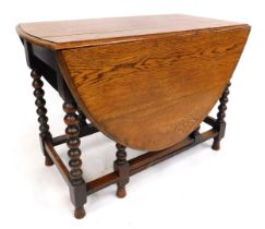 A 1920s oak oval gate leg table, with bobbin turned supports, flat stretchers, 73cm high, the top 10