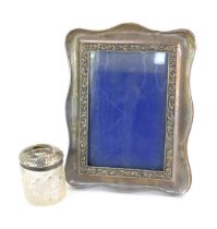 A 20thC silver photograph frame, of shaped rectangular form, embossed with floral and scroll motifs,