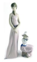 A Lladro porcelain figure, modelled as a young lady with hands crossed, 35cm high, together with a N