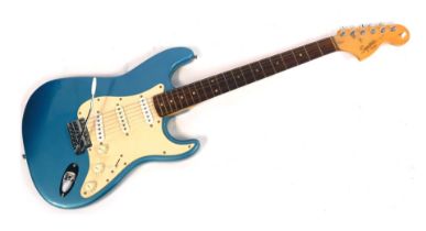 A Squier by Fender Strat electric guitar, on metallic blue backing, 99cm long.