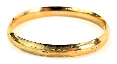 A 9ct gold hollow hinged bangle, with petallated and hammered decoration, 6cm diameter, 8.8g, boxed.
