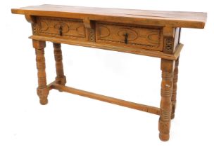 An Eastern hardwood side table, fitted with two drawers having carved detail, on turned legs with pl