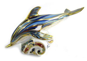 A Royal Crown Derby porcelain paperweight modelled as a dolphin, gold stopper and red printed marks,