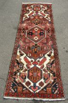 A Persian rug or runner, dark pink ground, with central floral medallion surrounded by further medal