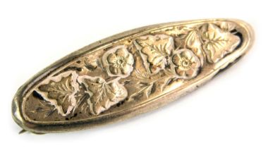 A Victorian silver bar brooch, oval embossed with flowers and vines, 4cm diameter, 3g.