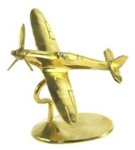 A brass model of a Spitfire, mounted on an oval base, 13cm high.